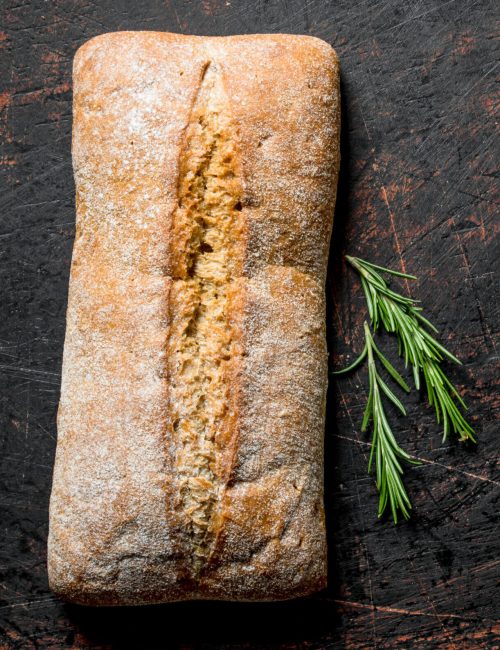 Bread ciabatta with rosemary. On dark rustic background