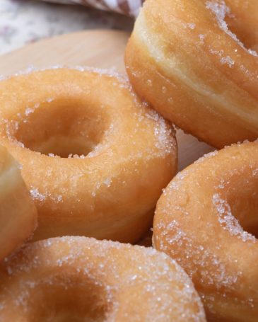 Sugar donuts on wooden board
